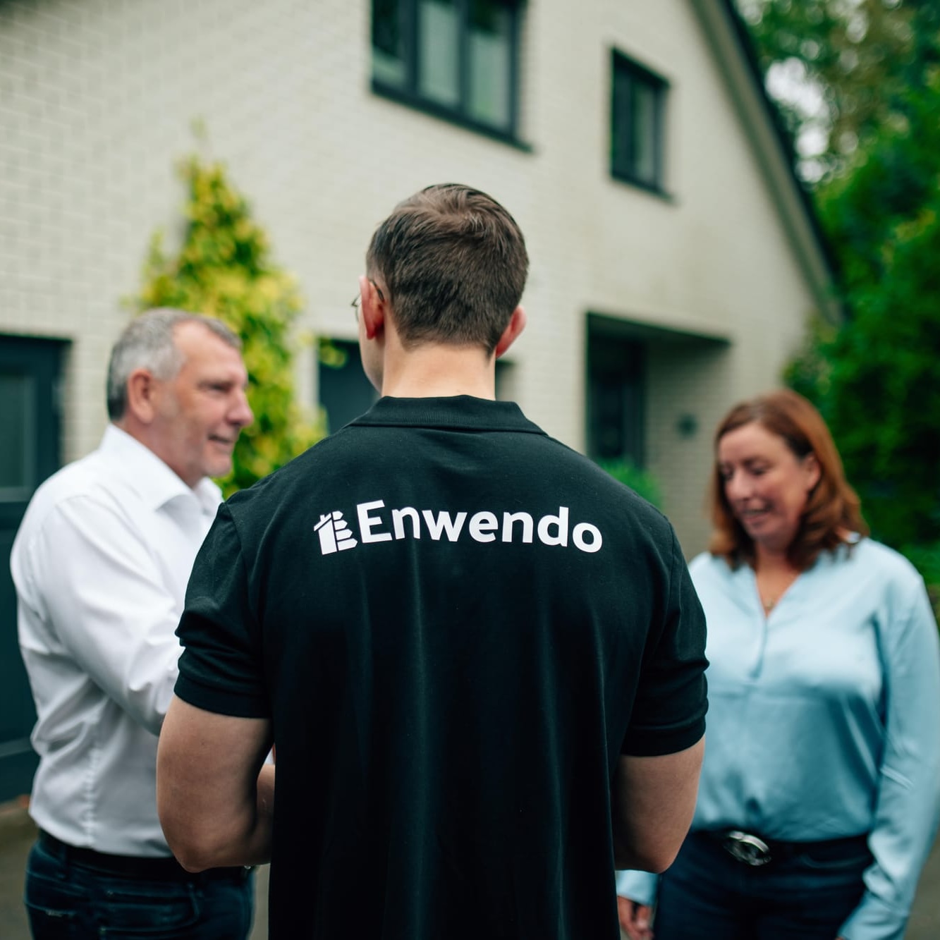 Enwendo Energieberater mit Kunden vor einem Einfamilienhaus